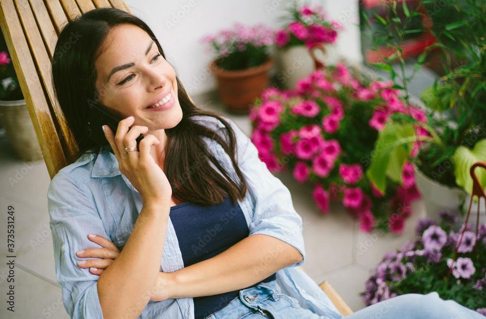 Young beautiful woman using mobile phone and relax at balcony. Young beautiful woman using mobile phone and relax at balcony.