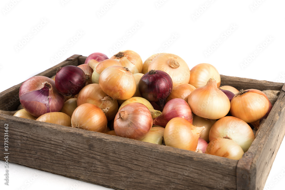 Yellow and red onions in a rustic wooden box isolated on a white background, side view. Full frame. Vegetable background. Concept of food, farm products. Yellow and red onions in a rustic wooden box isolated on a white background, side view. Full frame. Vegetable background. Concept of food, farm products.