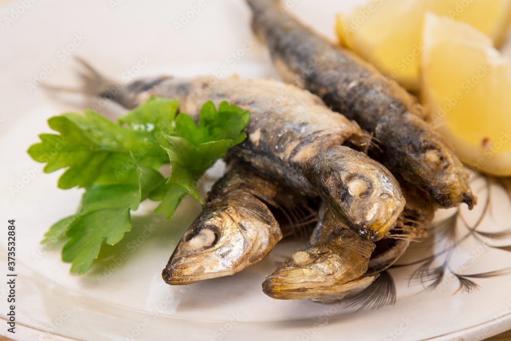 grilled sardines with lemon and parsley on the plate grilled sardines with lemon and parsley on the plate