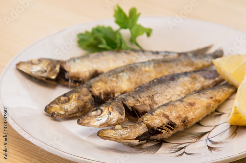 grilled sardines with lemon and parsley on the plate