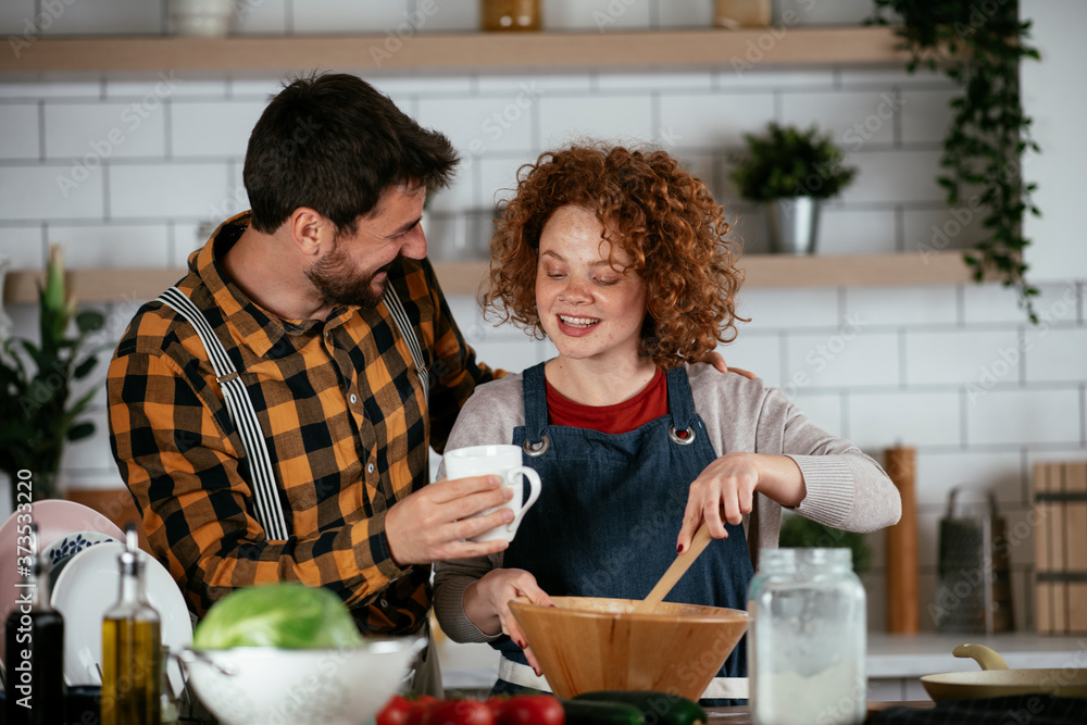 Boyfriend and girlfriend making delicious food at home. Loving couple cooking in kitchen.. Boyfriend and girlfriend making delicious food at home. Loving couple cooking in kitchen..