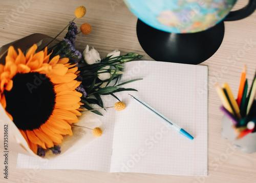 1 September. Bouquet with sunflower and school supplies on table. Hello autumn concept.  Back to school, Knowledge Day photo