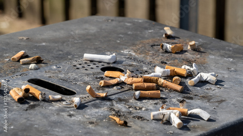Cigarette butts on an ashtray waste bin
