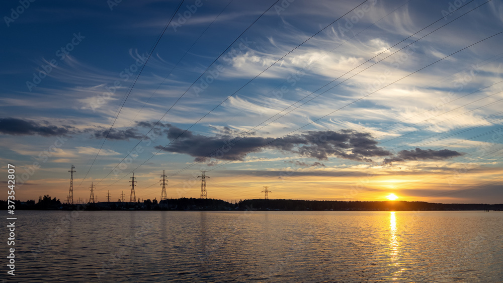 Panorama of the sunset with power lines on the river Bank, Russia, Ural