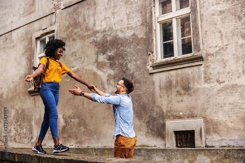 Young beautiful multicultural hipster couple having fun in and old part of the town.