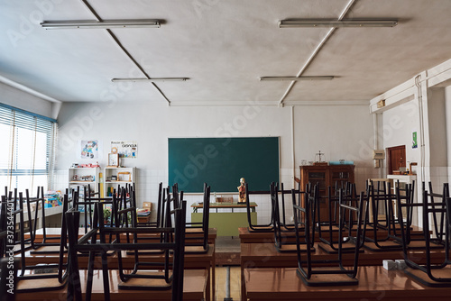 Chair and table in class room with green board background