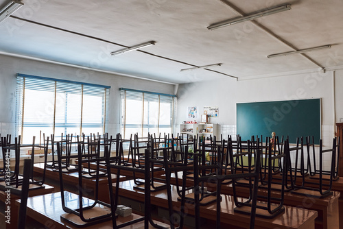 Chair and table in class room with green board background