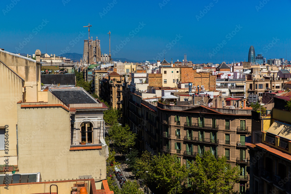 Top panoramic view of the Barcelona landscape from  the roof of Casa Mila, also known as La Pedrera, designed by Antonio Gaudi. Europe, Barcelona, Spain. Sagrada de Familia on the background.