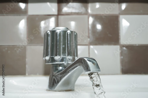 Water flowing from faucet in bathroom