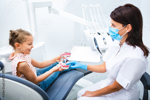Little patient playing with dentist. Smiling little girl visiting dentist. Children's teeth treatment.