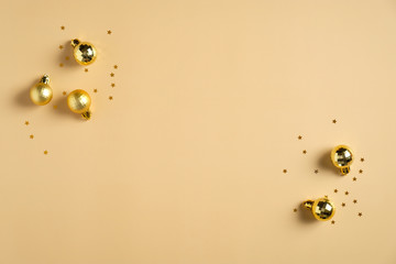 Christmas card mockup. Christmas flat lay composition with golden balls decorations and confetti on pastel yellow background. Top view with copy space.