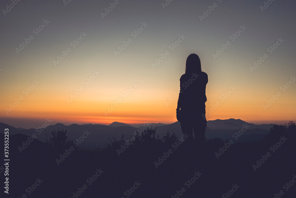 silhouette of a woman in the mountains