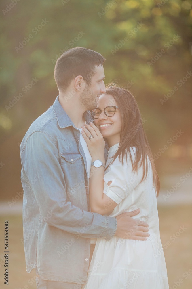 Beautiful young couple in sunbeams. A beautiful young couple is walking in the park. Summer. Beautiful young couple in sunbeams. A beautiful young couple is walking in the park. Summer.