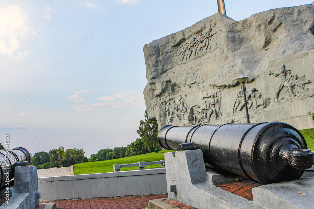 the ship's cannon is aimed at the sky against the background of a large gray monument.