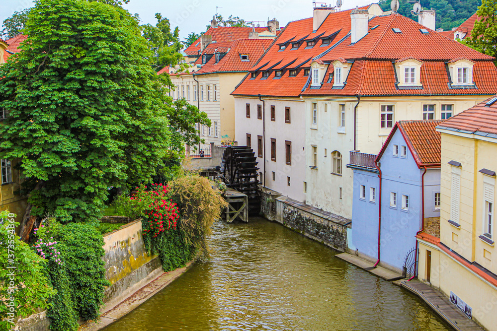 Obraz premium Summer European city. View of a cozy courtyard. River channel and water mill