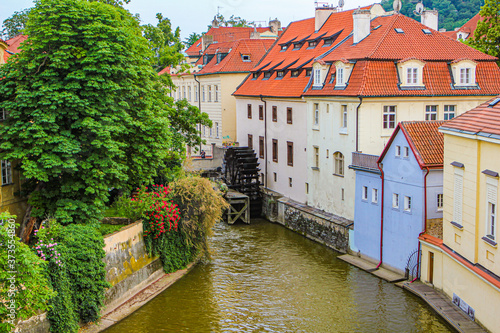 Summer European city. View of a cozy courtyard. River channel and water mill