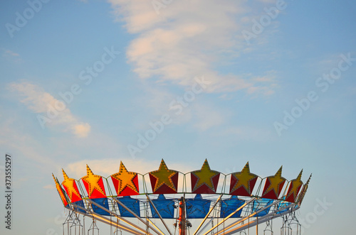 Top of colorful swing ride carousel with stars on the sky background