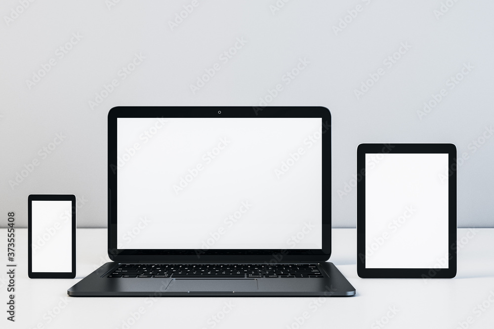 Laptop, digital tablet and cellphone with blank screen on table Laptop, digital tablet and cellphone with blank screen on table