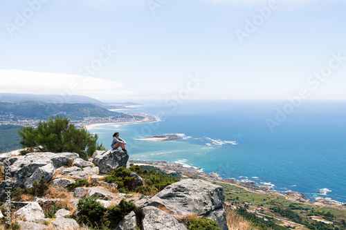 Attractive young female located on top of a rock witnessing the estuary of the Minho river in Galicia, north of Spain © Enrique
