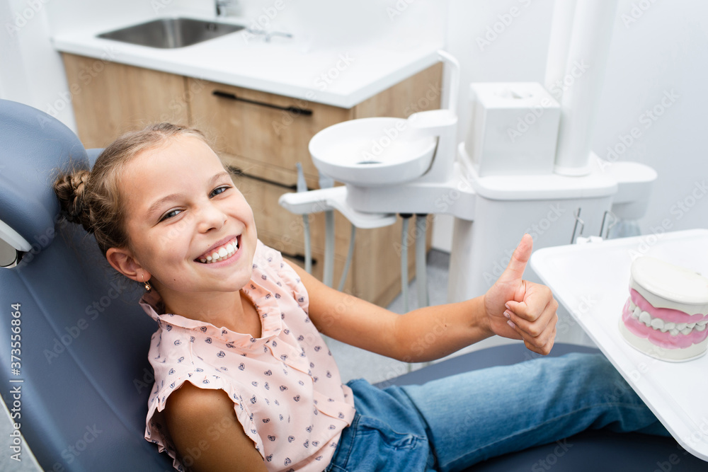 Very happy smiling girl sitting on a dental chair and showing thumbs up. Very happy smiling girl sitting on a dental chair and showing thumbs up.