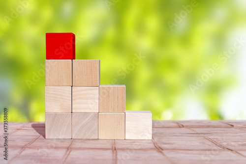 Wood cube arrange in pyramid shape ,business concept. The upper cube is red