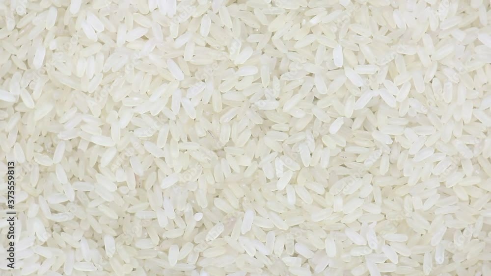 raw uncooked rice long grain spinning close-up raw uncooked rice long grain spinning close-up