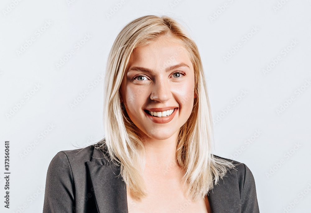 Portrait of a smiling girl pointing finger up at copyspace isolated on a white background. A woman points to an idea, a place for advertising. Positive blonde. Portrait of a smiling girl pointing finger up at copyspace isolated on a white background. A woman points to an idea, a place for advertising. Positive blonde.