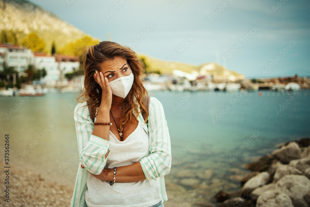Worried Young Woman With Protective Mask Thinking Of Something On The Beach