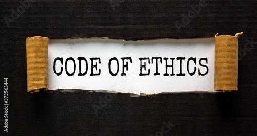 The words 'code of ethics' appearing behind torn black paper. Beautiful background. Business concept. photo