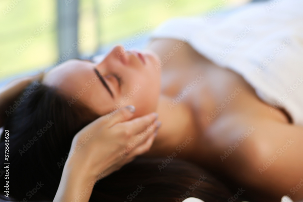 Obraz premium beautiful and healthy young woman relaxing with face massage at beauty spa salon