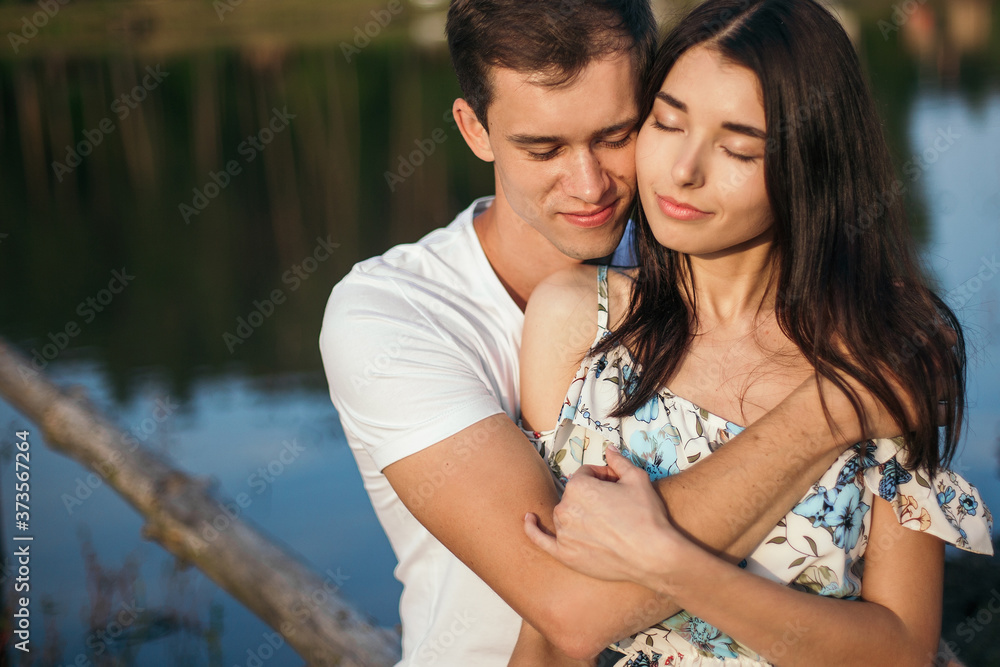 Young loving couple hugging near lake. Young loving couple hugging near lake.