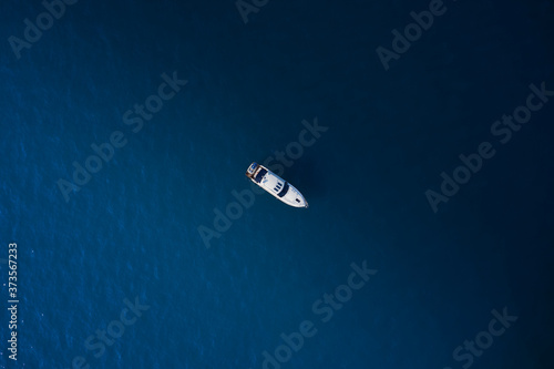 Large white yacht on calm blue water aerial view at high altitude