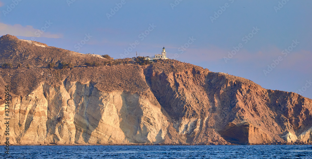 Naklejka premium Akrotiri lighthouse from Santorini Caldera at the golden hour