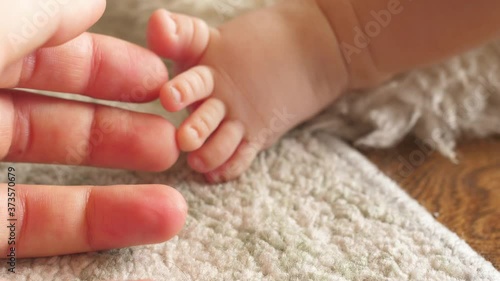 hand holding little cute newborn child foot fingers tootsy  photo