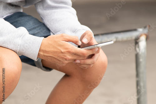 hands of young man with mobile phone on the street