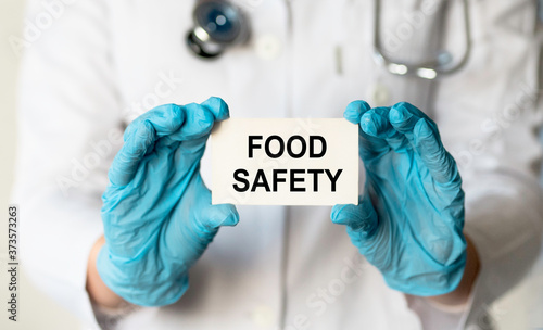 Doctor holding a card with text Food Safety, medical concept