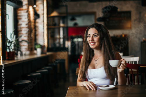 Beautiful woman drinking coffee sitting in a cafe.