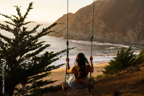 Girl Swinging Away on Tree Swing Overlooking California Beach