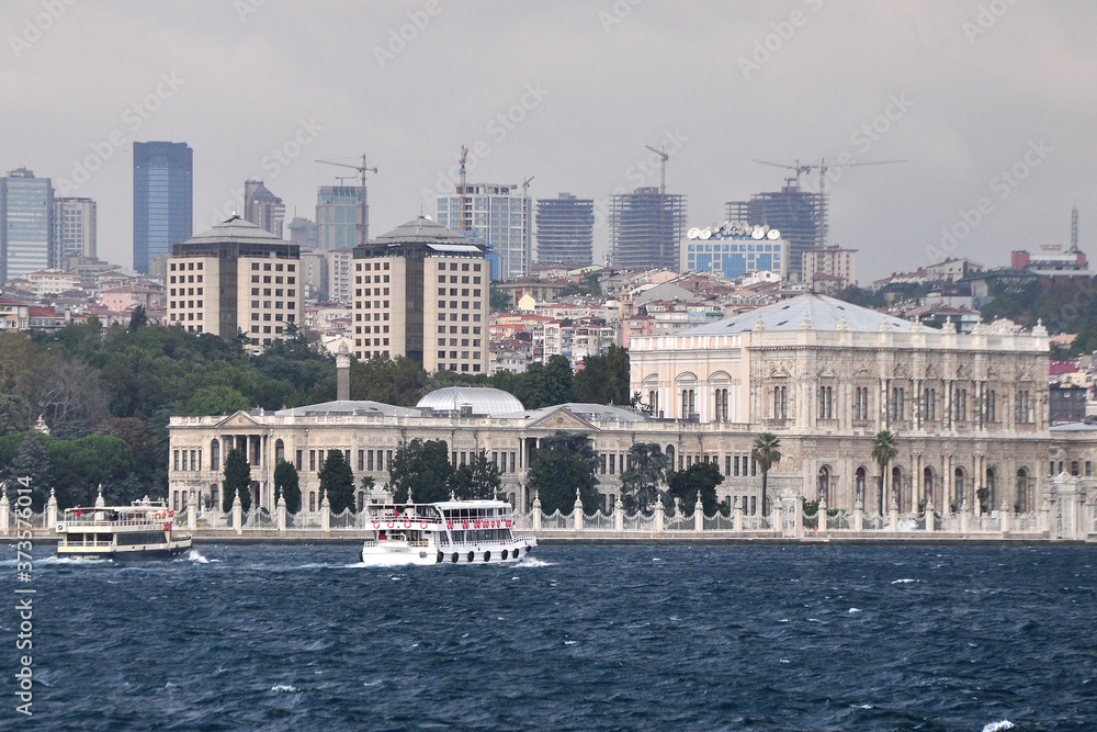 The Dolmabahce Palace viewed from offshore. The Istanbul city skyline provides a backdrop.