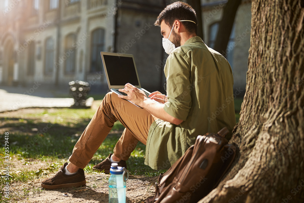 Obraz premium Concentrated male student working on his laptop