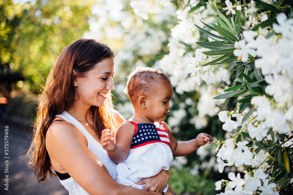 mother and daughter of mixed race looking at white flowers mother and daughter of mixed race looking at white flowers