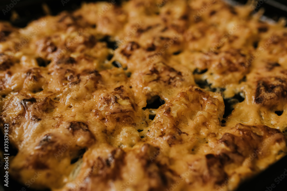 Meat cheese pizza. Baked meat in the oven lies on a black metal baking sheet. mouth-watering cheese sauce. Meat cheese pizza. Baked meat in the oven lies on a black metal baking sheet. mouth-watering cheese sauce.