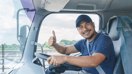 Fotografia Happy smiling of professional truck driver in a long transportation and delivery