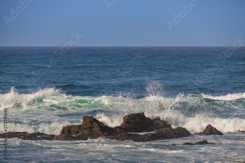 Waves breaking on large rocks in ocean © Martina