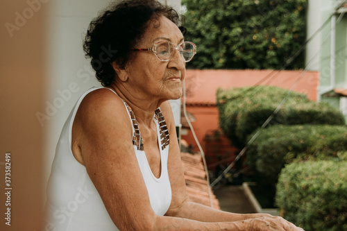 Thoughtful elderly Brazilian woman on her home's balcony during quarantine