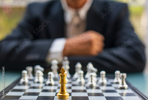 One chess pieces staying against full set of chess pieces with background of businessman. Strategy, Planning and Decision concept