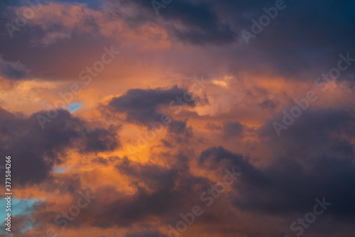 Purple clouds illuminated by disappearing rays at sunset. Majestic weather meteorology background. Motion blur, soft focus