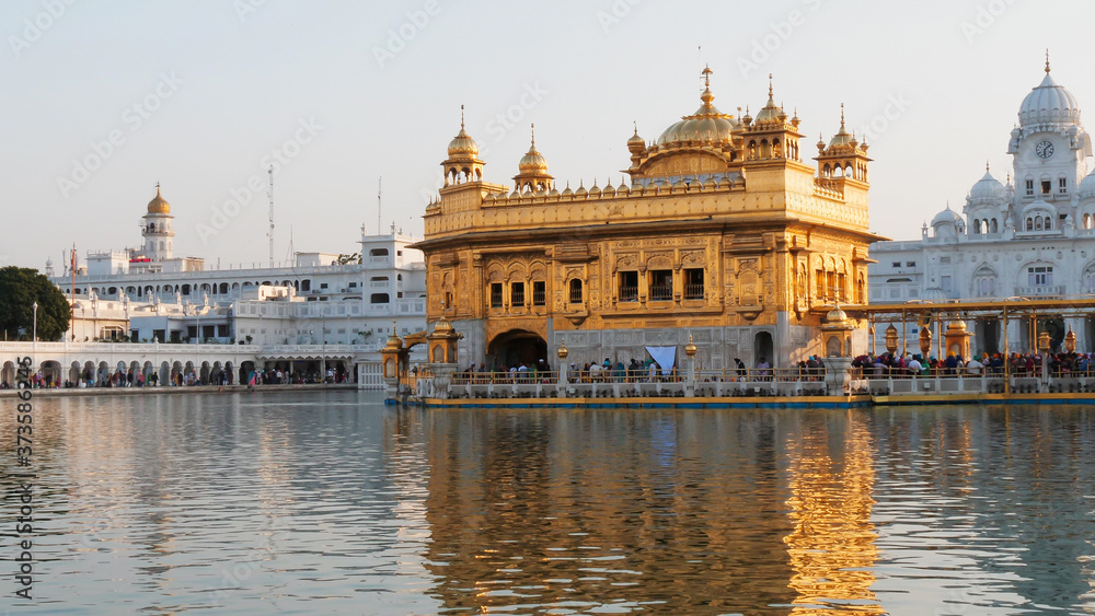 Fototapeta premium close view of the golden temple and the surrounding pool in amritsar