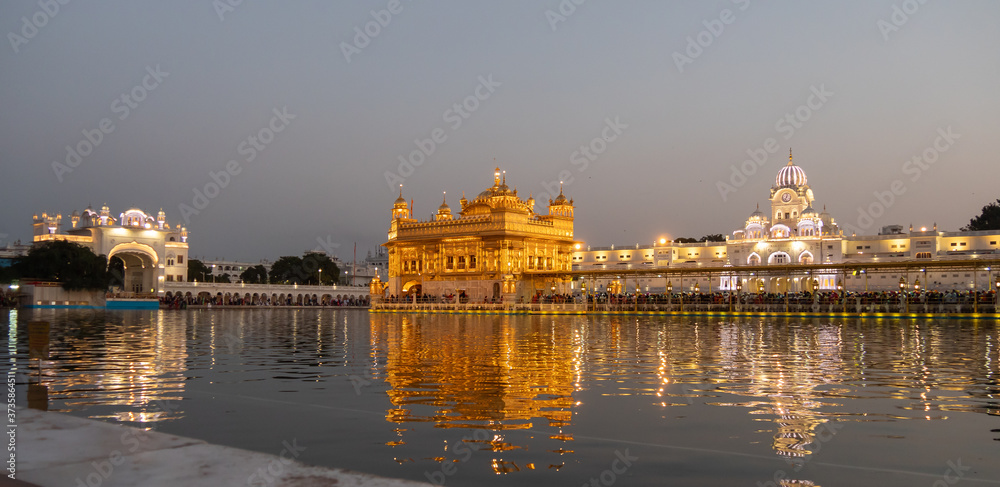 a wide angle shot of the beautiful golden temple at dusk in amritsar