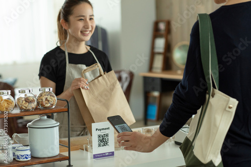 キャッシュレス決済をする客と店員